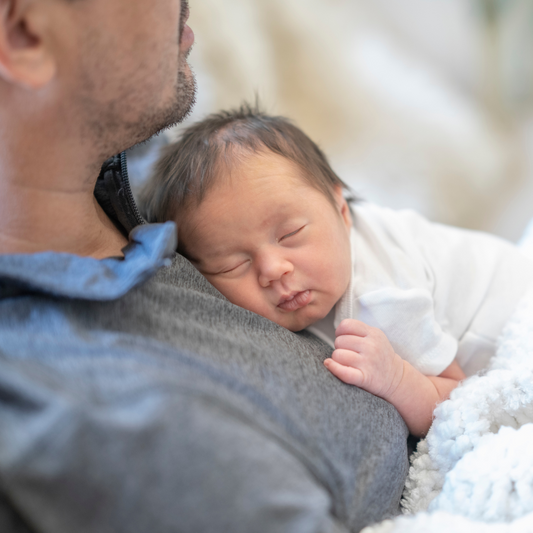 Baby sleeping on dad's chest