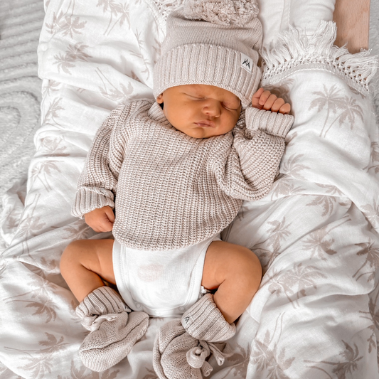 Newborn Baby laying on the palm fringe swaddle blanket