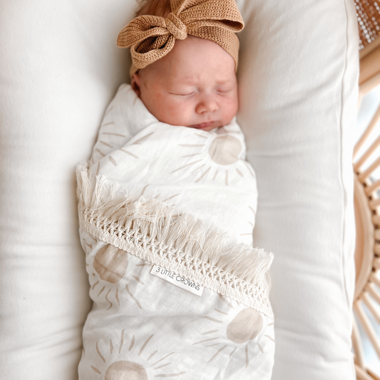 Sleeping Newborn swaddled with Sun Fringe Swaddle Blanket