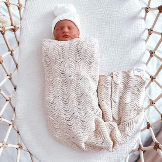 Oat Wave Knit Blanket swaddled on baby