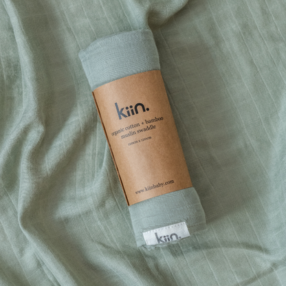 Kiin Swaddle in Sage rolled on open swaddle